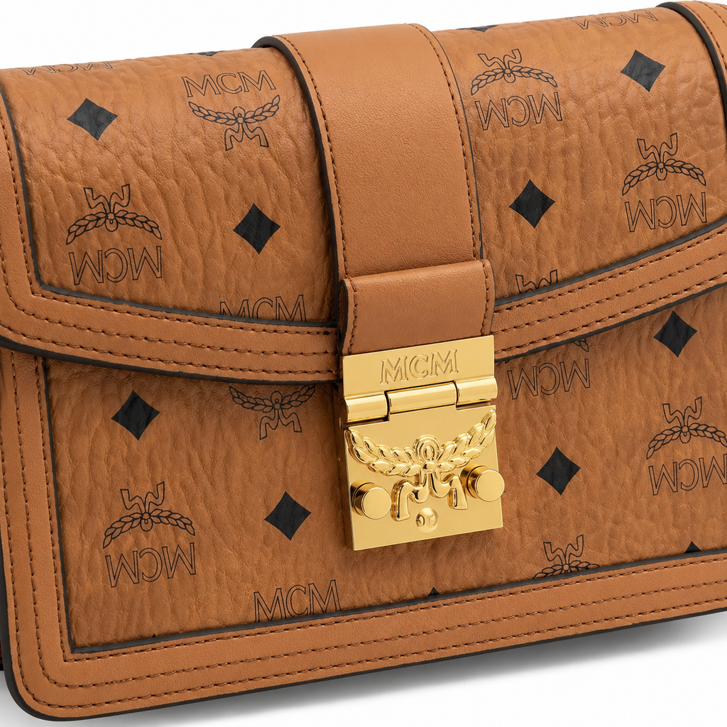 Made in MCM cognac-colored Visetos canvas featuring a gold logo clasp adjustable shoulder strap and a lightweight messenger bag style suitable for both men and women