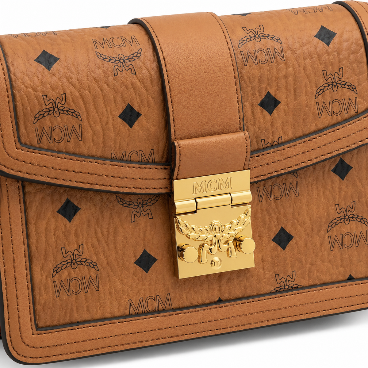 Made in MCM cognac-colored Visetos canvas featuring a gold logo clasp adjustable shoulder strap and a lightweight messenger bag style suitable for both men and women