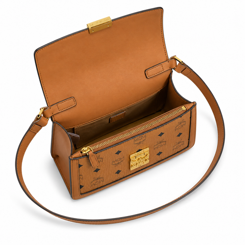 Made in MCM cognac-colored Visetos canvas featuring a gold logo clasp adjustable shoulder strap and a lightweight messenger bag style suitable for both men and women