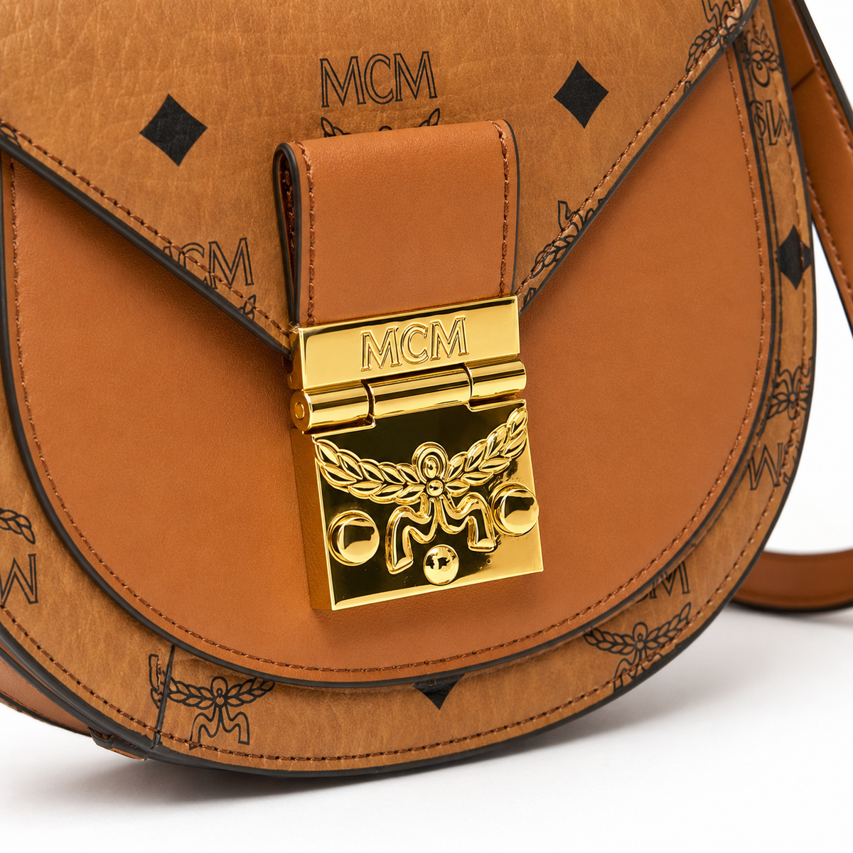 MCM Cognac-colored all-over monogram canvas bag with gold-plated clasp pendant adjustable shoulder strap for single-shoulder or crossbody wear