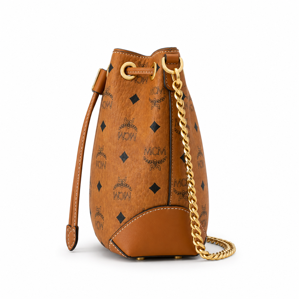 MCM Cognac-colored all-over monogram canvas bag with adjustable shoulder strap can be carried by hand over the shoulder or crossbody