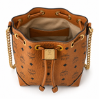 MCM Cognac-colored all-over monogram canvas bag with adjustable shoulder strap can be carried by hand over the shoulder or crossbody