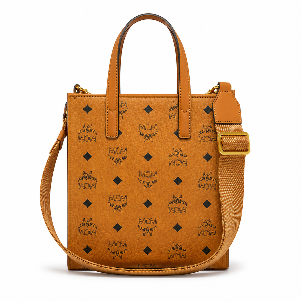 MCM cognac-colored full-width Monogram canvas with an adjustable webbing shoulder strap, suitable as a tote bag, shoulder bag, or crossbody bag.  Product Details