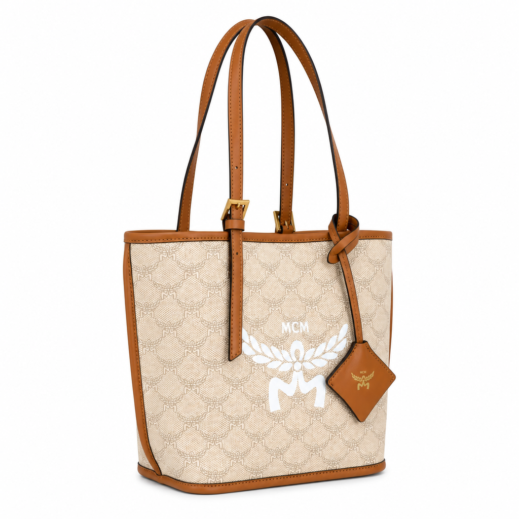 MCM beige laurel leaf with cognac-colored calfskin trim white logo and diamond pendant adjustable handle can be carried by hand over the shoulder or crossbody